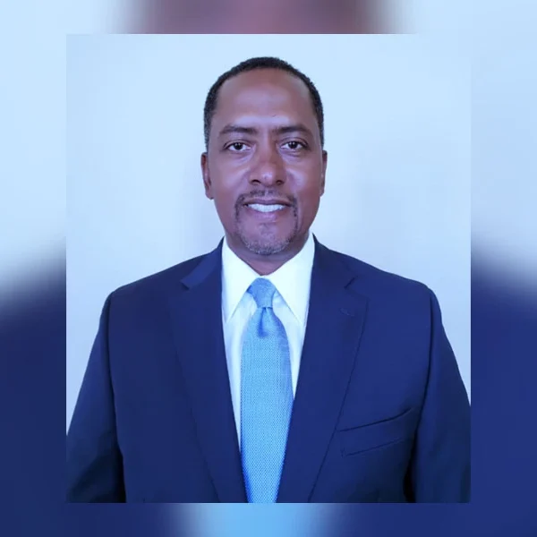 Cortez Richardson wearing a navy suit and blue tie in a professional headshot