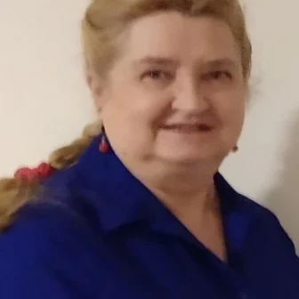 Polly Korzekwa smiling in a blue blouse, presenting a warm and professional presence